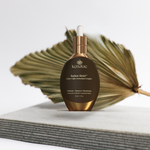 Kenalae Radiant Shield serum bottle on a light background with a dried leaf